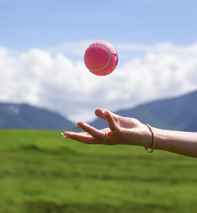 Tennis ball tossed in the air against a Boquete mountain backdrop at Lucero