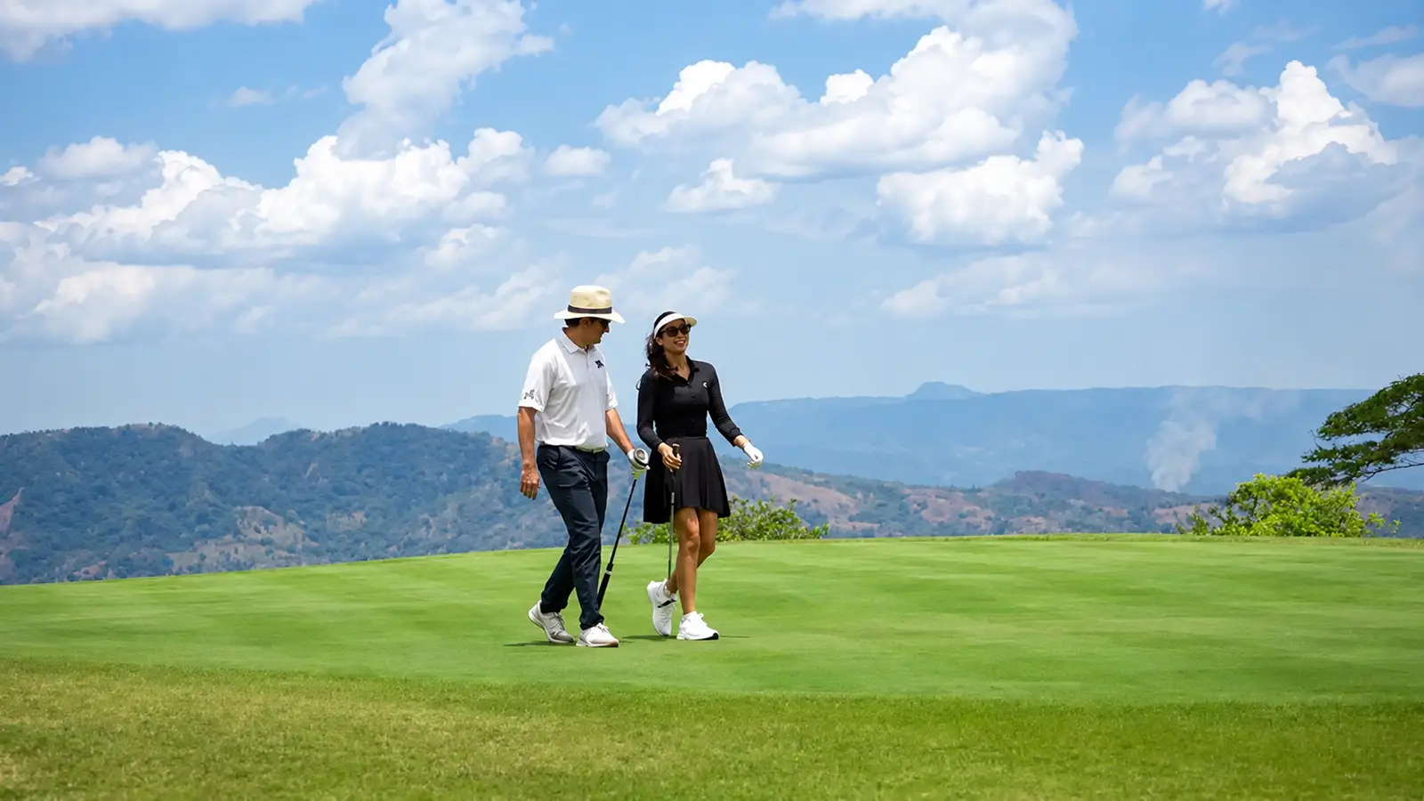 Couple walking the fairway with mountain views at Lucero Golf and Country Club