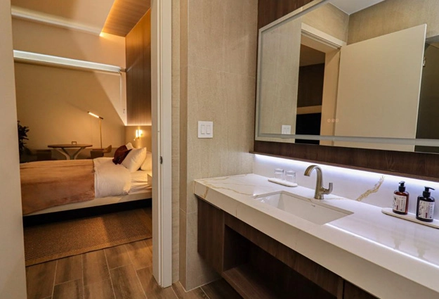 Baño de Canopy Suite con tocador de mármol y vista al dormitorio