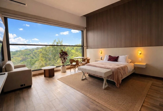 Dormitorio de Canopy Suite con ventanales de piso a techo hacia el valle de Boquete